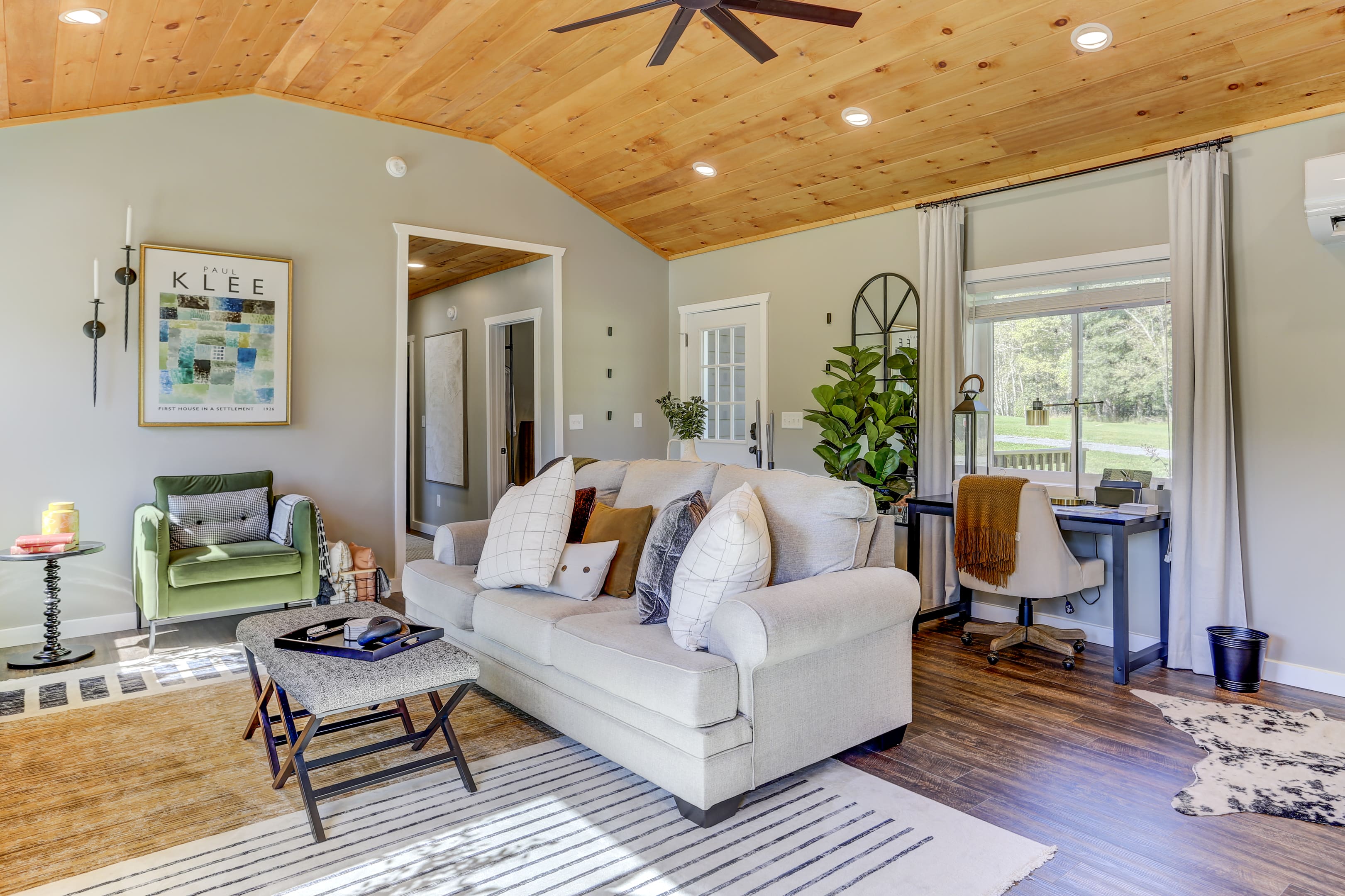 A living room with white furniture and wood ceiling.